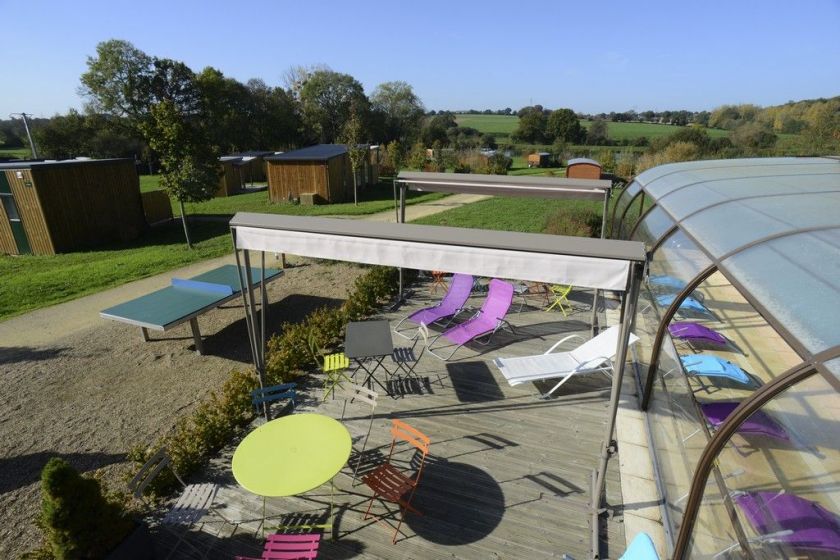 La terrasse de la piscine couverte et chauffée et la vue sur le domaine du Moulin